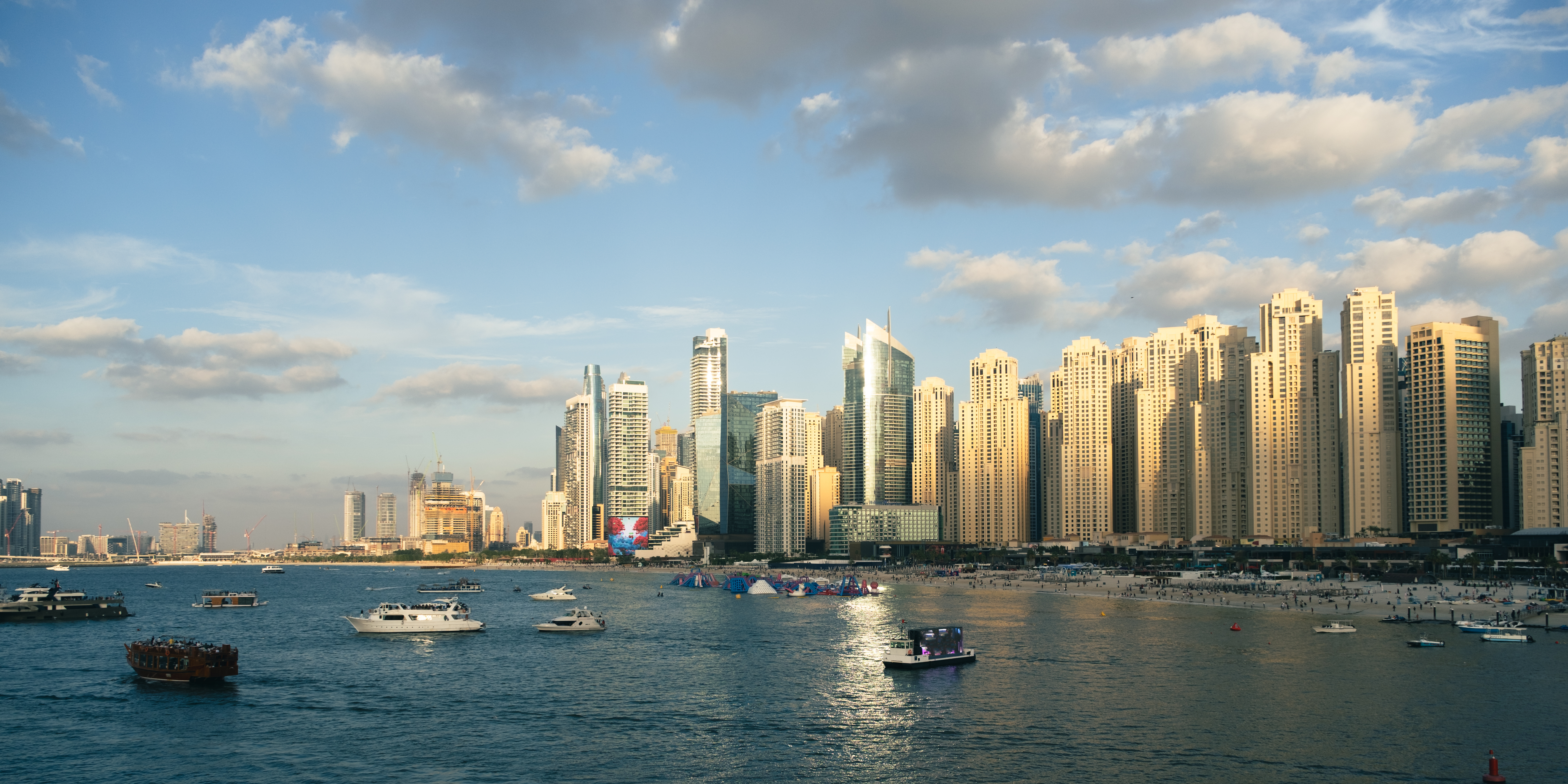 Real Dubai waterfront skyline with boats crossing the bay