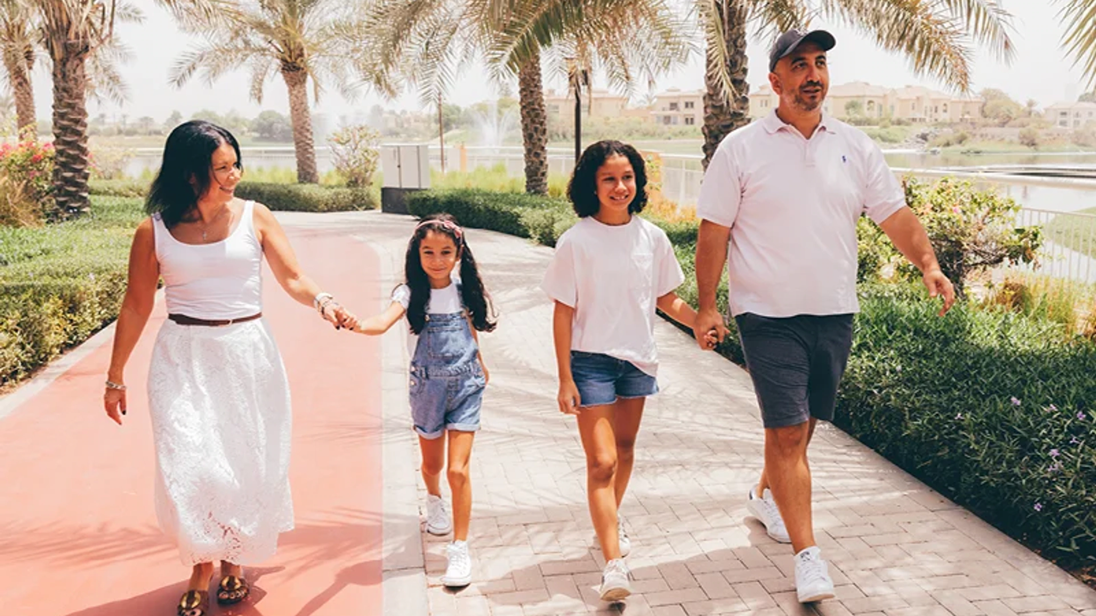 Family walking along a landscaped path beside water
